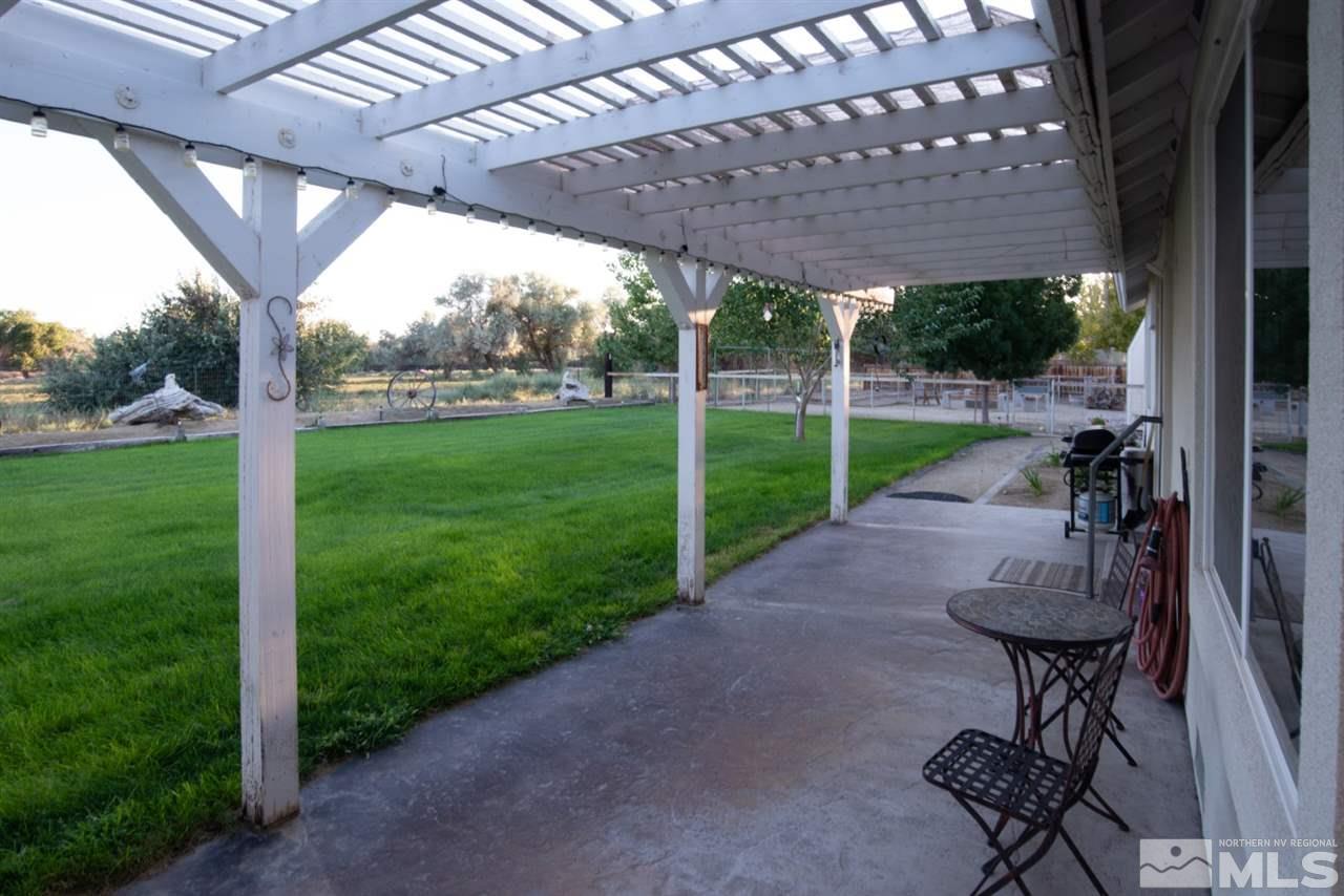 4767 Rancheria Road Fallon, NV 89406 - Photo 22 of 25 a view of a backyard with table and chairs under an umbrella with a small yard