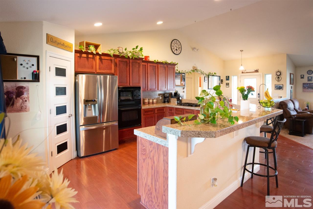 4767 Rancheria Road Fallon, NV 89406 - Photo 8 of 25 a kitchen with stainless steel appliances kitchen island granite countertop a refrigerator and a stove