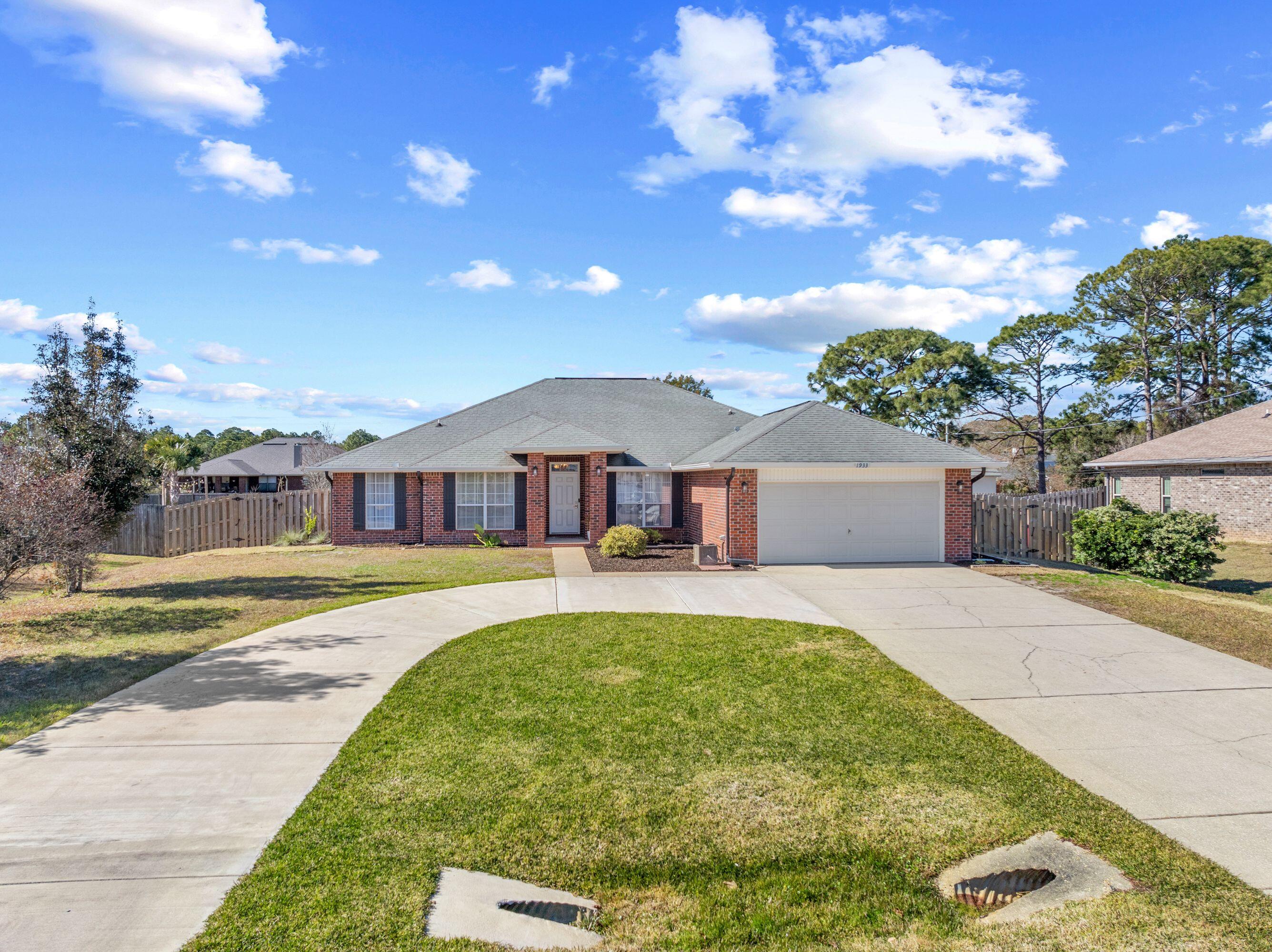 1933 Eagle Lane Navarre, FL 32566 - Photo 3 of 40 a front view of a house with a garden and trees