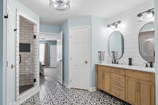 a bathroom with a double vanity sink mirror and shower