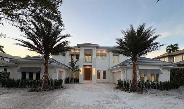 a front view of a house with a tree
