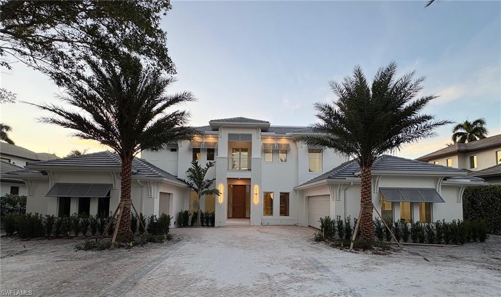 a front view of a house with a tree