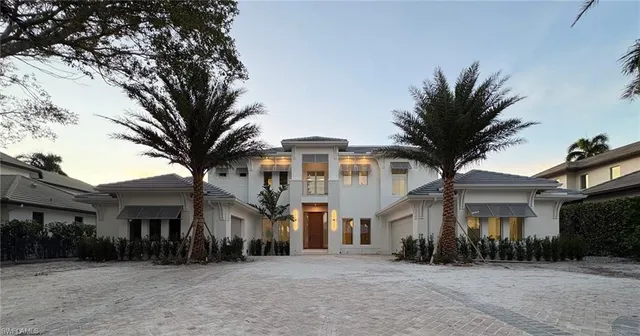 a front view of a house with a tree