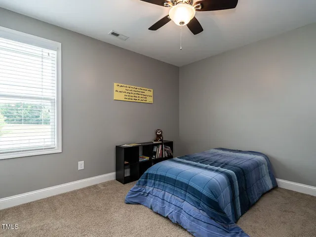 a bedroom with a large bed and a chandelier