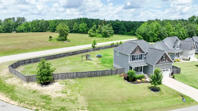 a view of a house with a yard and potted plants