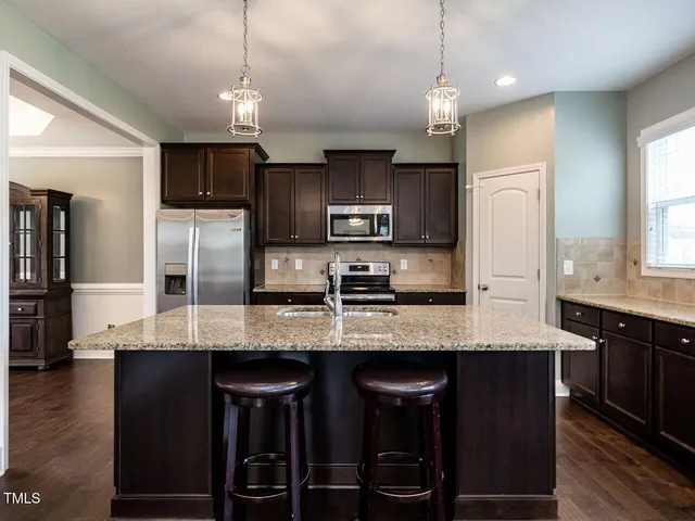 a kitchen with stainless steel appliances granite countertop a sink refrigerator and microwave