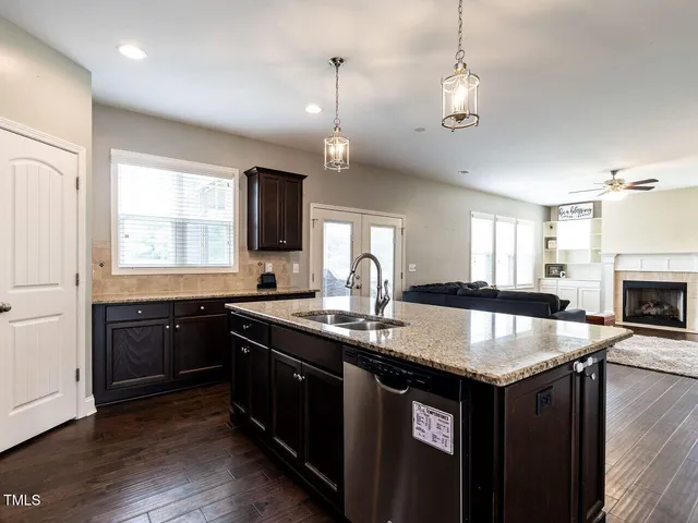 a kitchen with granite countertop stove top oven and refrigerator