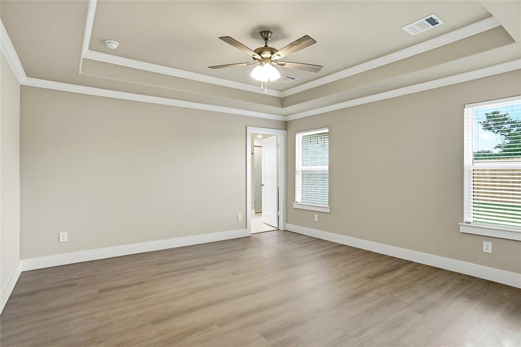 133 Joel Street Springtown, TX 76082 - Photo 7 of 15 a view of an empty room with wooden floor and a window