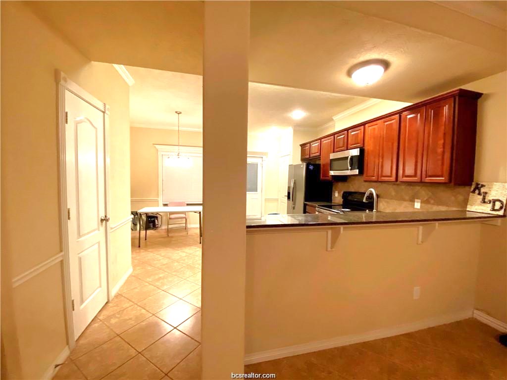 1000 Spring Loop, Unit 1705 College Station, TX 77840 - Photo 3 of 12 a view of a kitchen with kitchen island granite countertop a refrigerator cabinets and a sink
