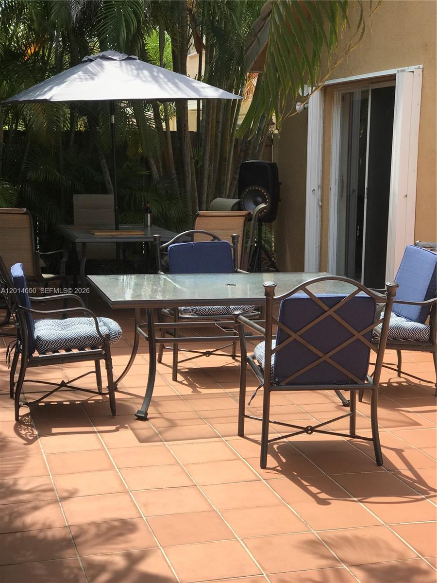 16654 Southwest 103rd Lane Miami, FL 33196 - Photo 20 of 20 a view of backyard with table and chairs under an umbrella