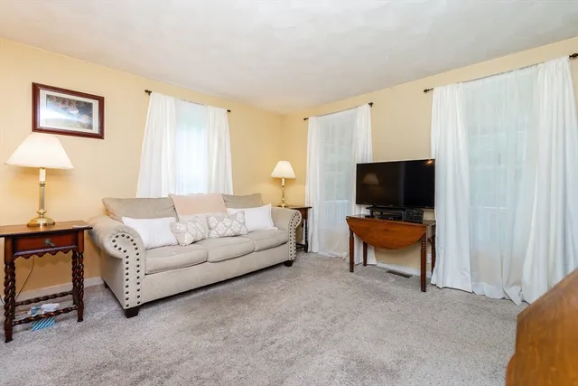 a living room with furniture a lamp and a flat screen tv