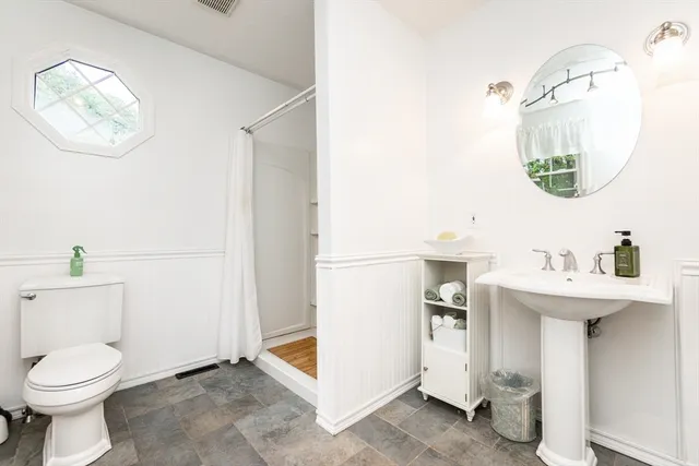 a bathroom with a sink a toilet and a mirror