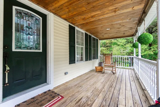 a balcony with wooden floor and furniture