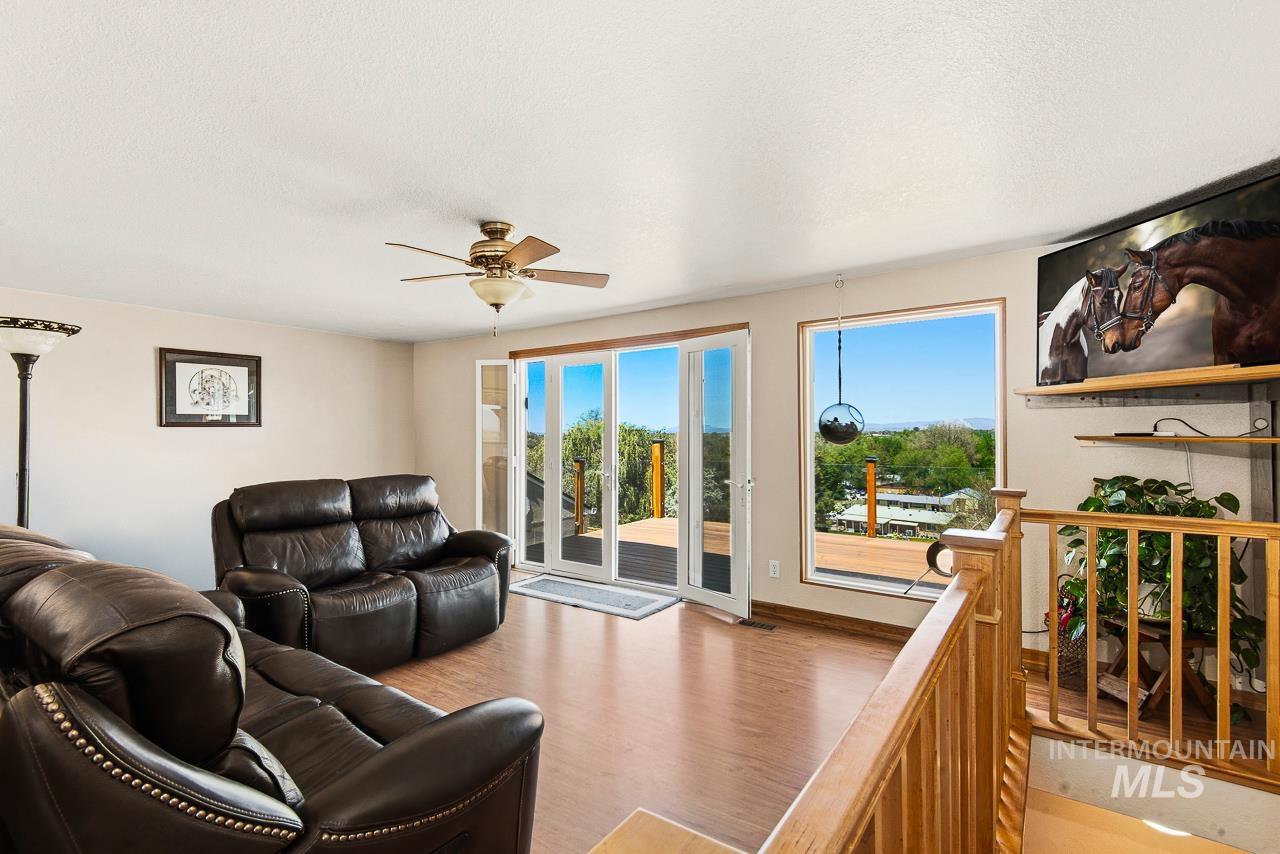 10178 West Fox Ridge Drive Boise, ID 83709 - Photo 5 of 36 Spacious living area featuring wood-finish flooring and a ceiling fan