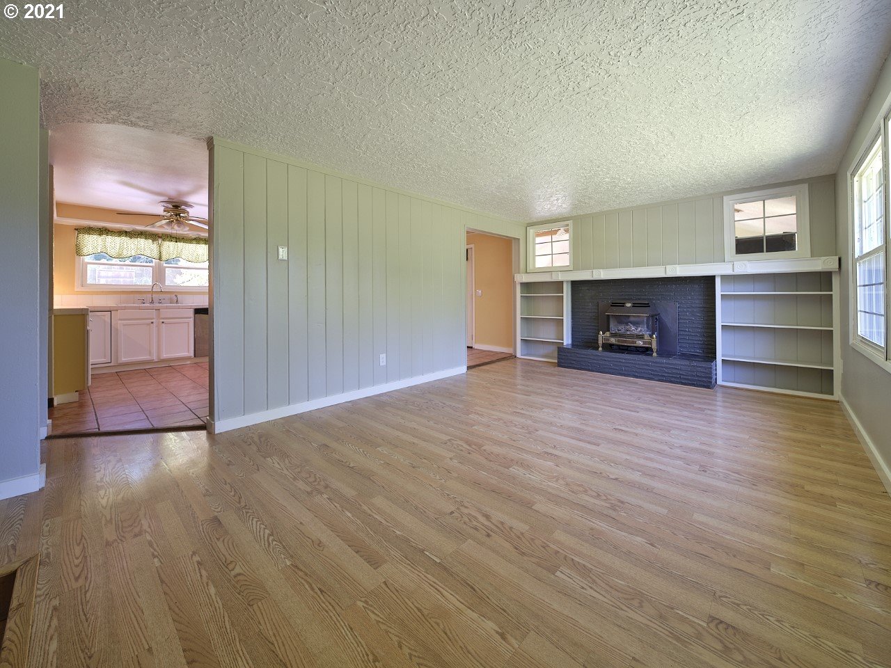 6121 Northeast Lessard Road Camas, WA 98607 - Photo 9 of 26 an empty room with wooden floor fireplace and windows