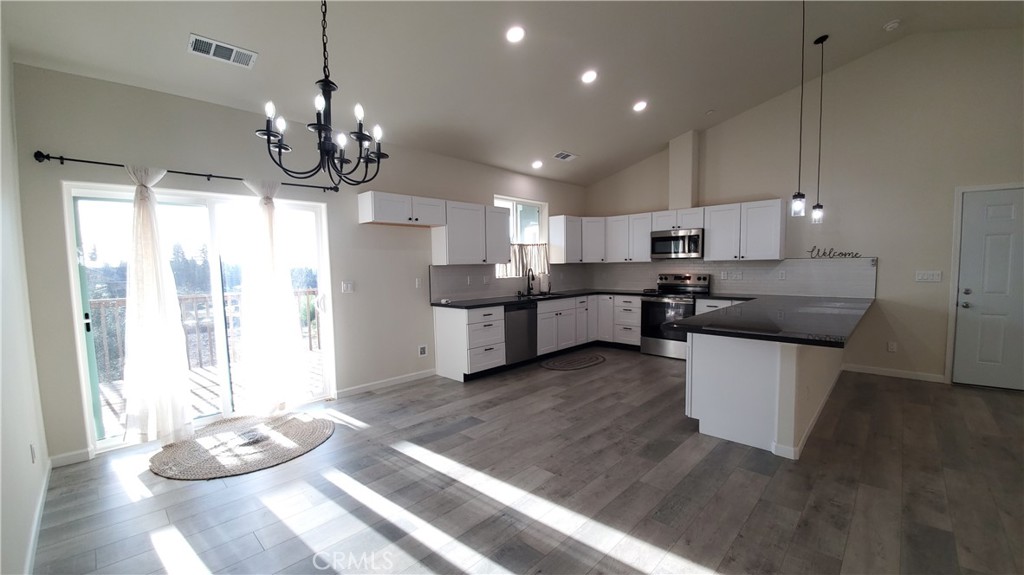 6282 Hartnell Court Magalia, CA 95954 - Photo 24 of 33 a large kitchen with stainless steel appliances kitchen island granite countertop a table and chairs in it