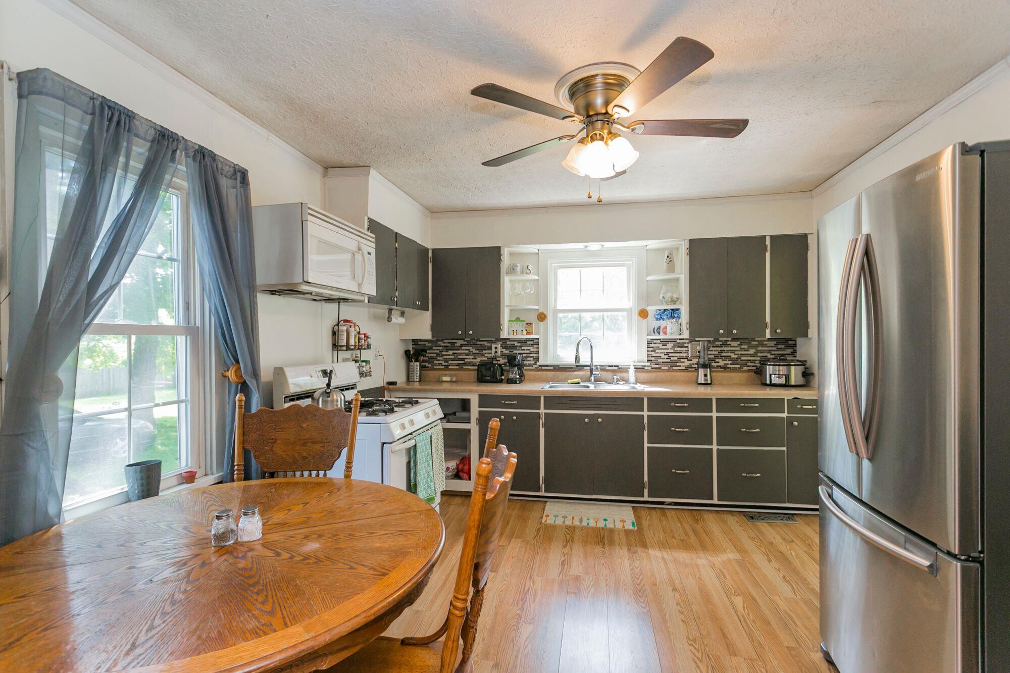 108 North Street Portland, TN 37148 - Photo 10 of 21 a kitchen with stainless steel appliances a stove a refrigerator a sink dishwasher a dining table and chairs with wooden floor