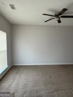 a view of a room with a window and a ceiling fan