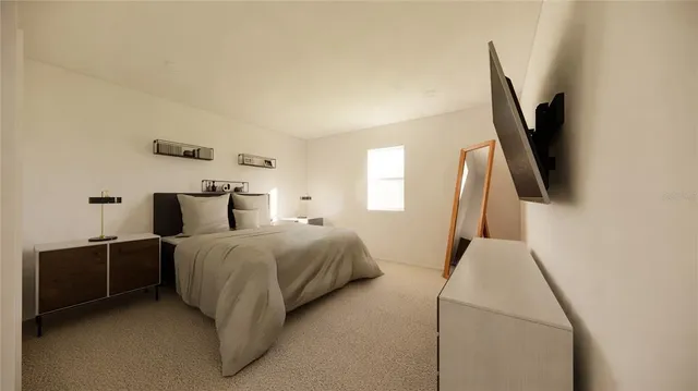 a bedroom with a bed and a flat tv screen on the dresser