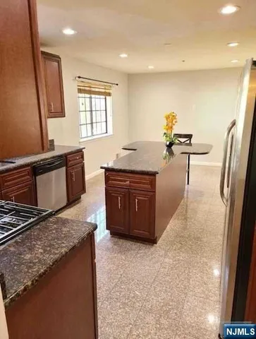 a kitchen with stainless steel appliances granite countertop a sink and a stove