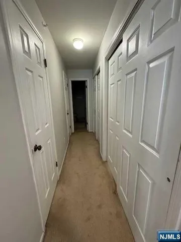 a view of a hallway with a white door and stairs