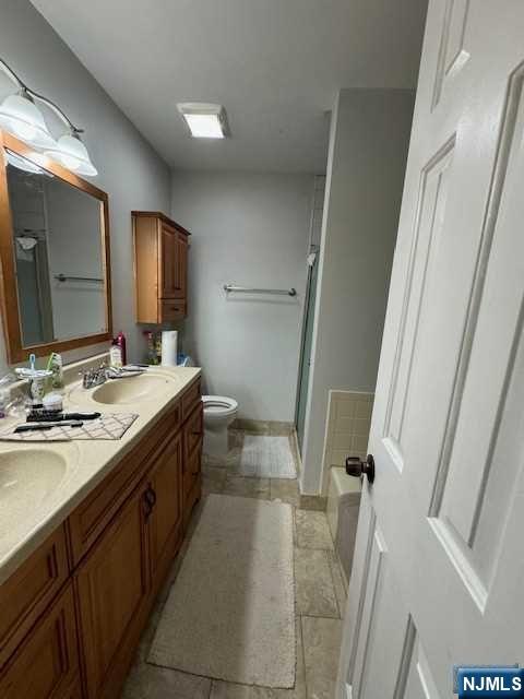 1209 Faulkner Court Mahwah, NJ 07430 - Photo 10 of 11 a bathroom with a double vanity sink mirror and toilet