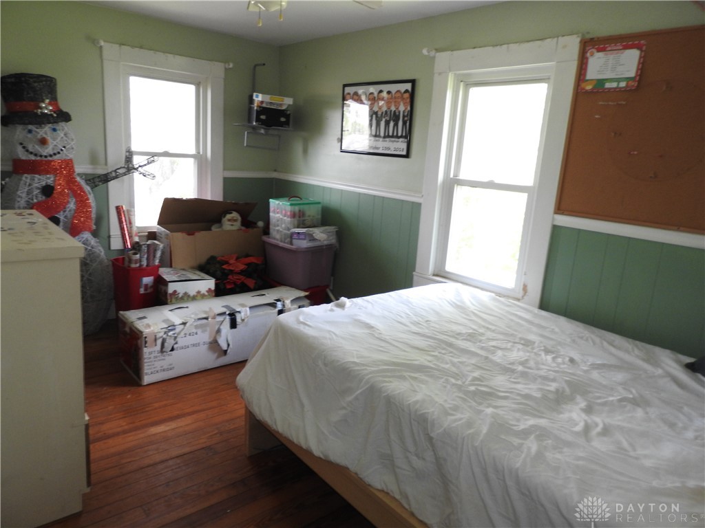 2105 East Loy Road Piqua, OH 45356 - Photo 25 of 26 This cozy bedroom features hardwood floors and ample natural light, creating a comfortable living space.