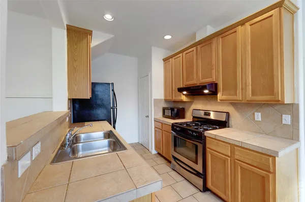 a kitchen with stainless steel appliances a stove a sink and a refrigerator