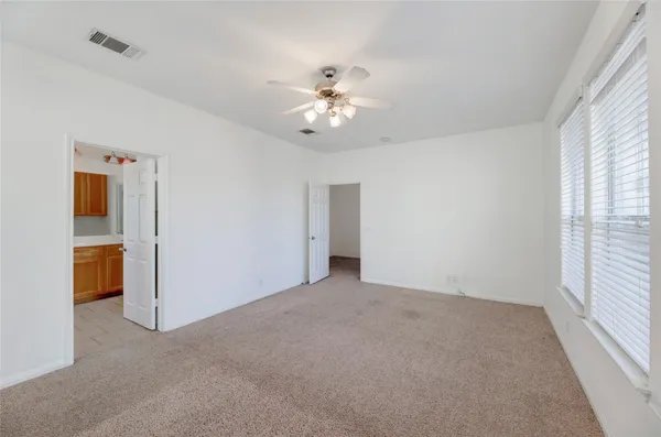 an empty room with closet and a ceiling fan