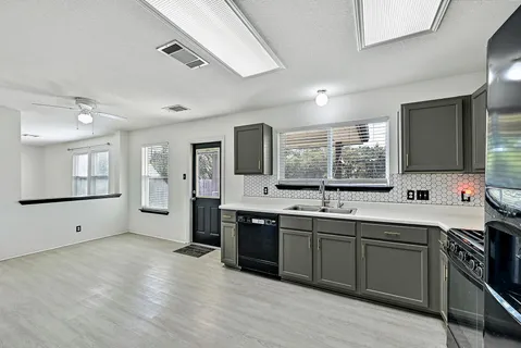 a large kitchen with stainless steel appliances granite countertop a sink and cabinets with wooden floor