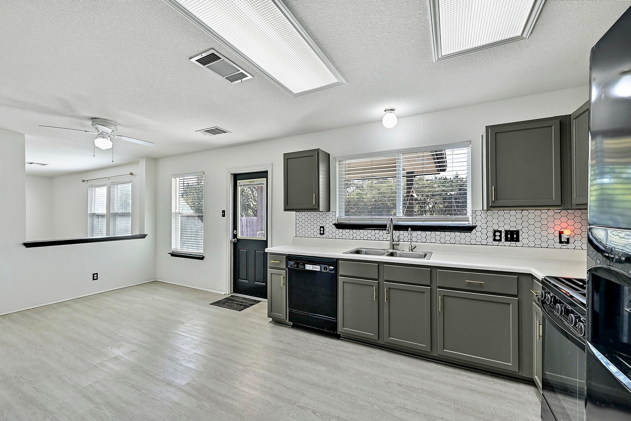 102 Cannery Cove Leander, TX 78641 - Photo 12 of 37 a large kitchen with stainless steel appliances granite countertop a sink and cabinets with wooden floor