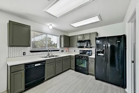 a kitchen with stainless steel appliances granite countertop a sink stove and refrigerator
