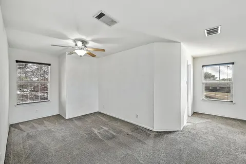 a view of a livingroom with an empty space and a ceiling fan