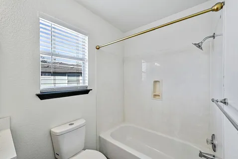 a white toilet sitting next to a bath tub shower