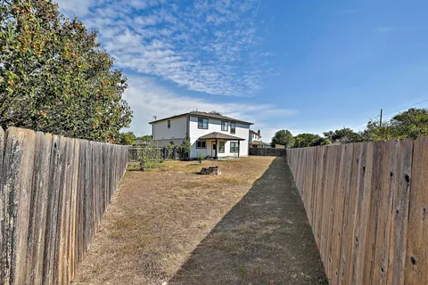 a view of a yard in front of a house with wooden fence
