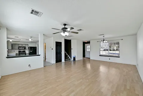 a view of an empty room with window and a fireplace