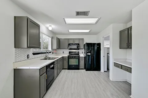 a kitchen with stainless steel appliances granite countertop a refrigerator and a stove top oven