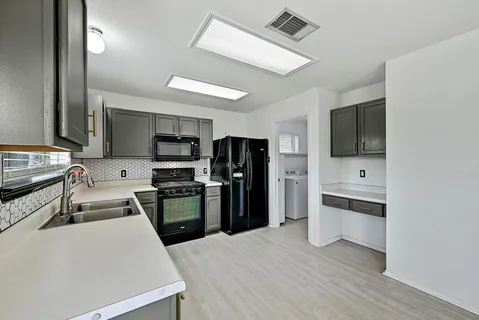 a kitchen with stainless steel appliances a refrigerator and a stove top oven