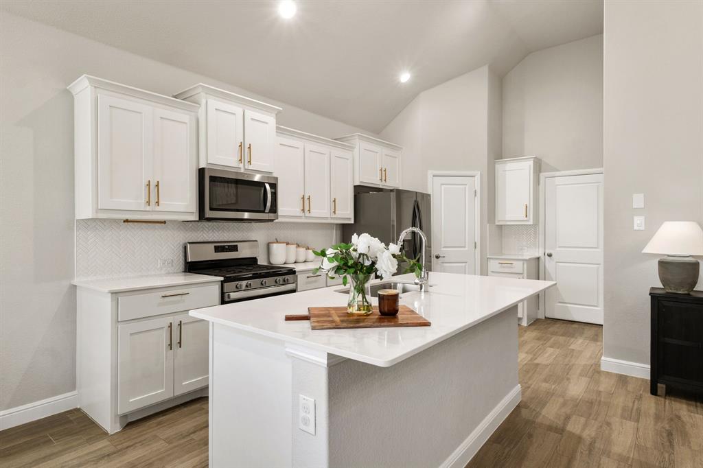 a kitchen with stainless steel appliances a stove microwave sink and refrigerator