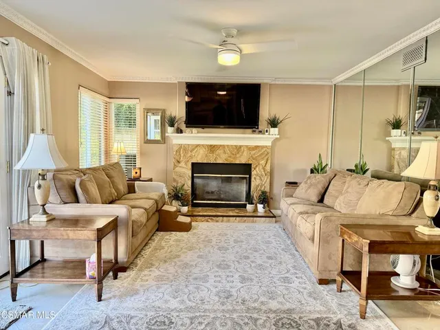 a living room with furniture a flat screen tv and a fireplace