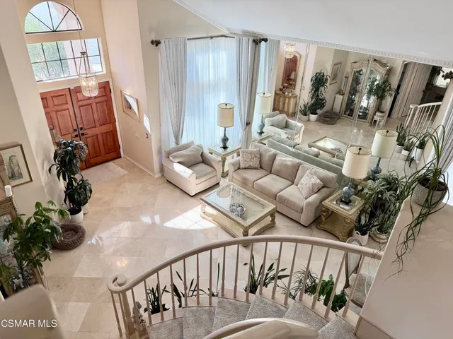 a living room with furniture stairs and a wooden floor