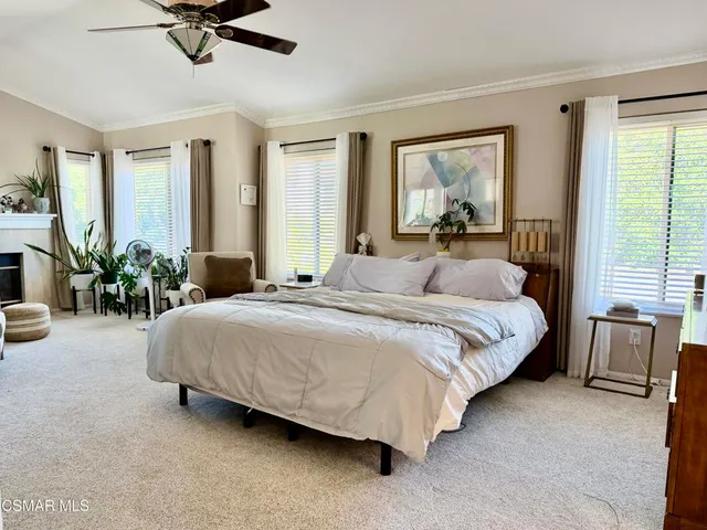 a bed sitting in a spacious bedroom next to a window
