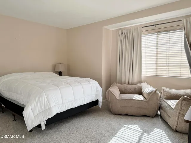 a bedroom with a bed couch and a window