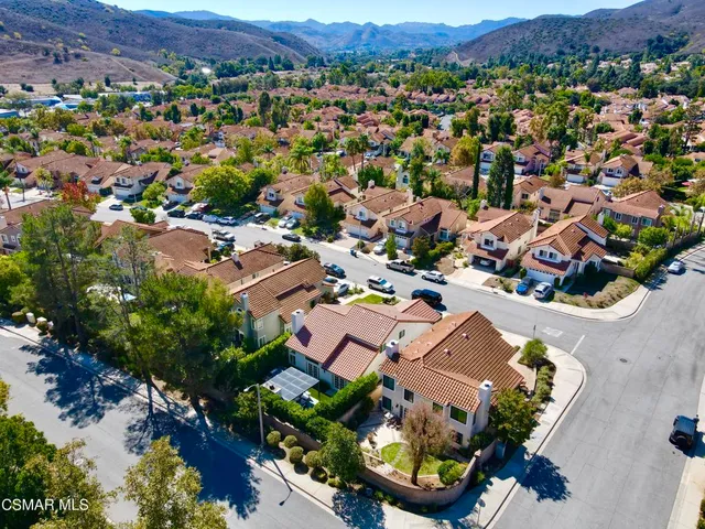 an aerial view of residential houses with outdoor space and parking