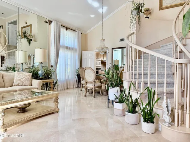 a living room with furniture potted plant and a mirror