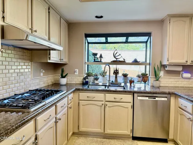 a kitchen with stainless steel appliances granite countertop a stove and cabinets
