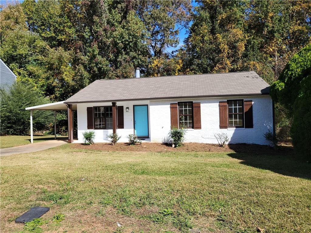 5560 Pine Gate Drive Atlanta, GA 30349 - Photo 1 of 1 a front view of a house with a garden and yard