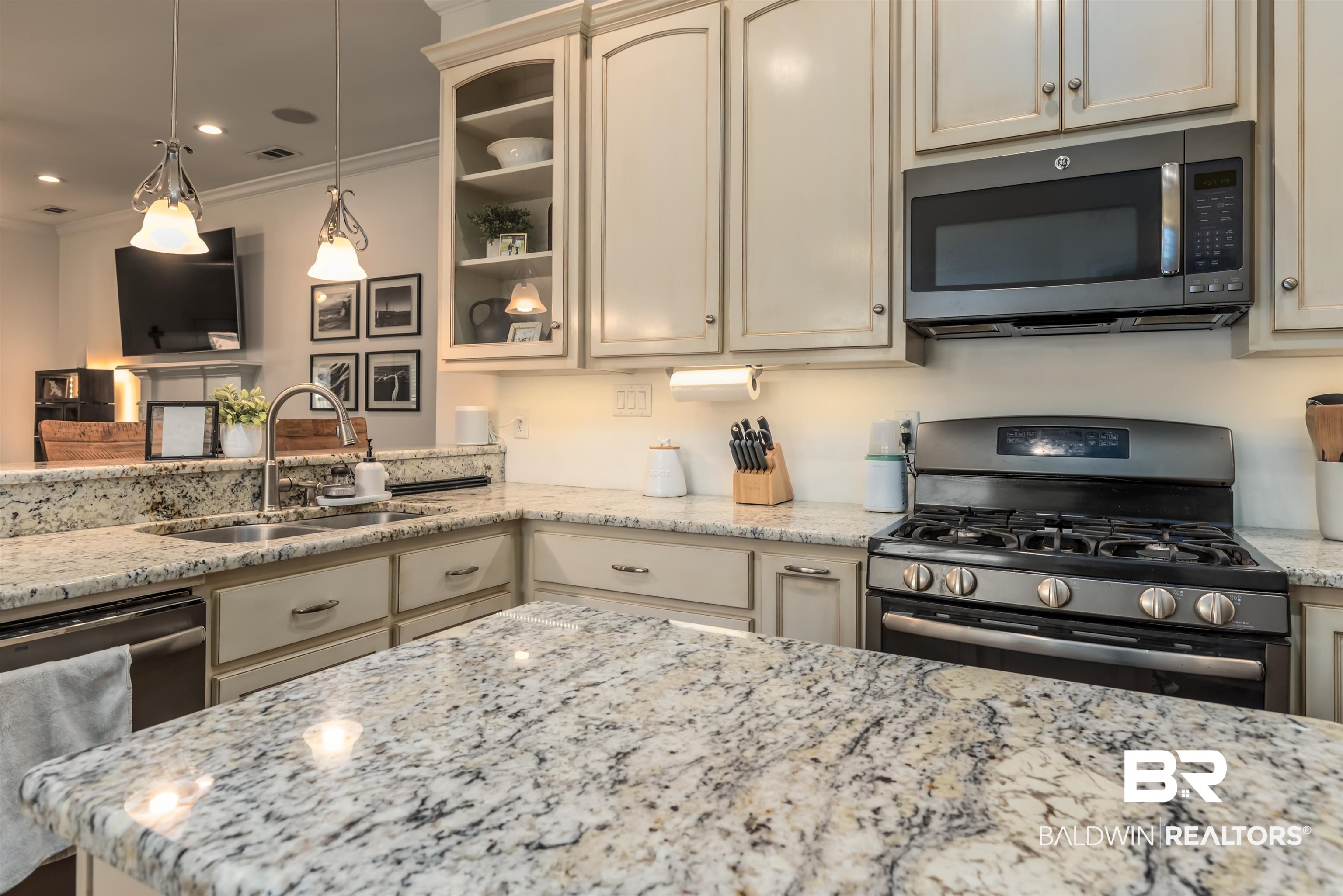 965 Henckley Avenue Mobile, AL 36609 - Photo 9 of 30 Kitchen featuring appliances with stainless steel finishes, sink, ornamental molding, and light stone countertops