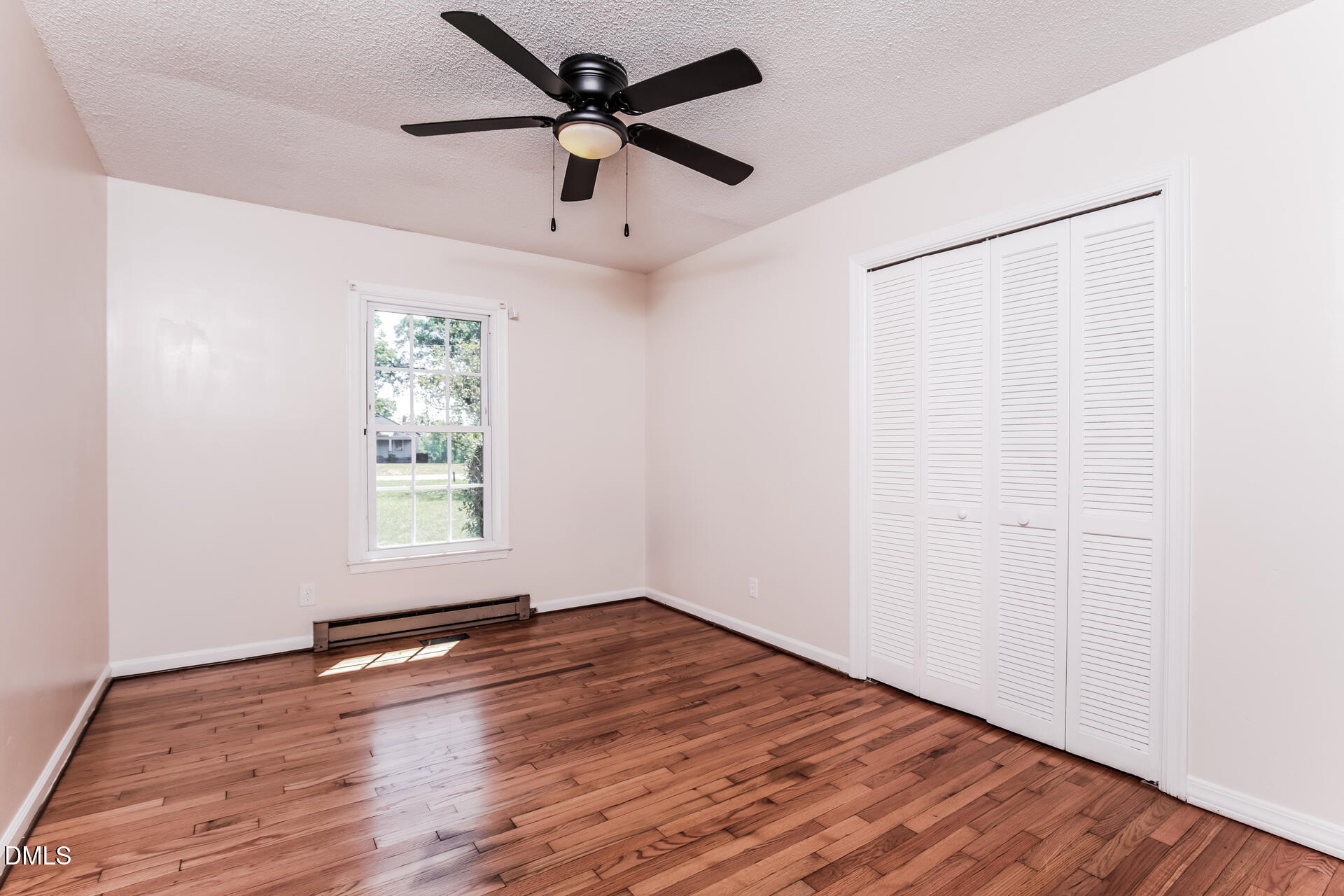 870 Abbott Road Henderson, NC 27537 - Photo 4 of 20 an empty room with wooden floor fan and windows