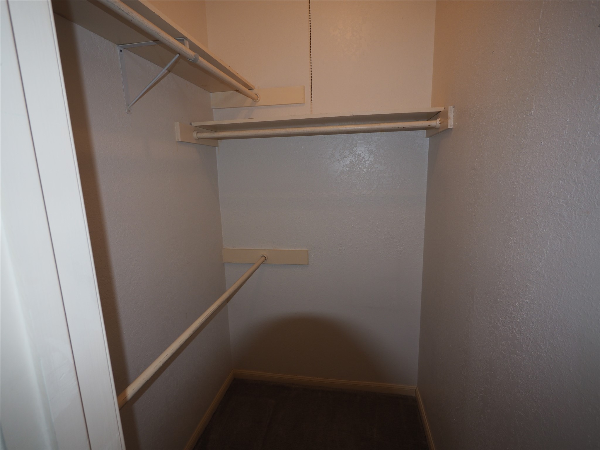2508 Enfield Road, Unit 10 Austin, TX 78703 - Photo 13 of 17 Closet featuring multiple shelving units and clothing rods, textured walls, and baseboard trim